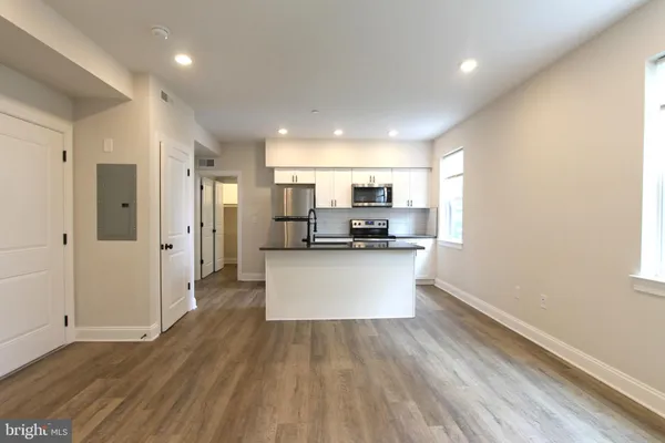 a view of kitchen with stainless steel appliances refrigerator sink and cabinets