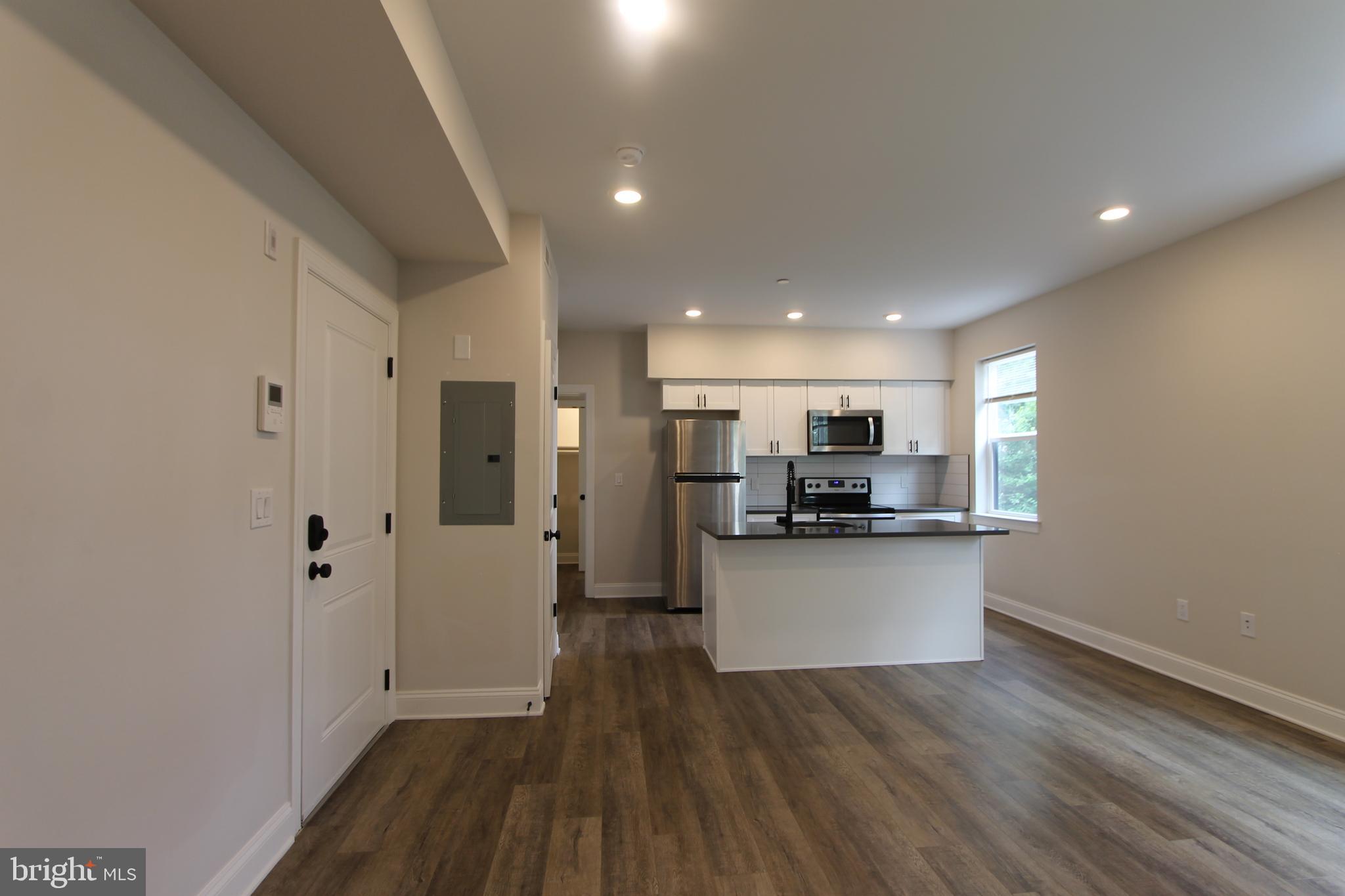 492 Roxborough Avenue, Unit 403 Philadelphia, PA 19128 - Photo 4 of 28 a kitchen with stainless steel appliances a refrigerator and a stove top oven