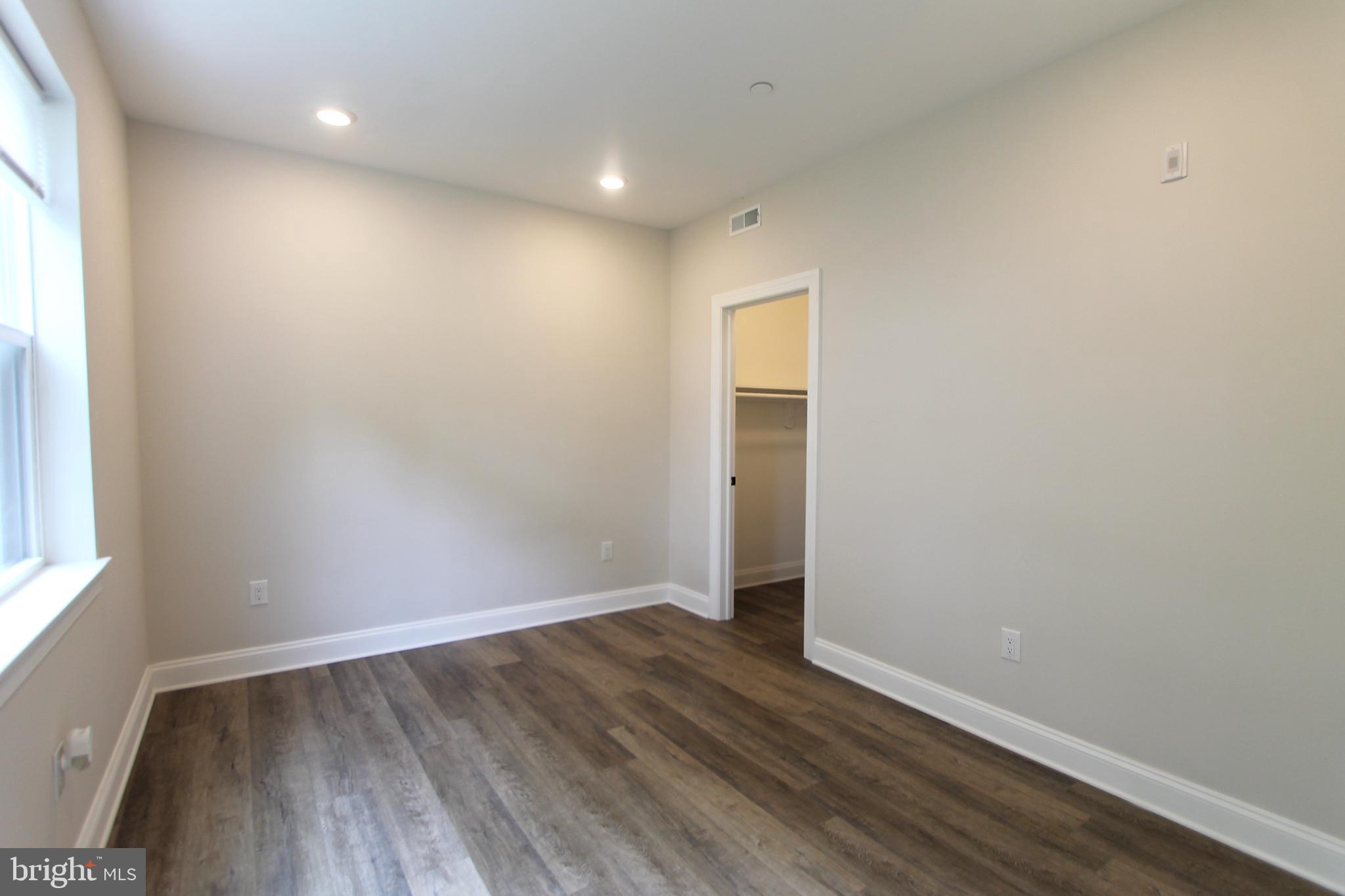 492 Roxborough Avenue, Unit 403 Philadelphia, PA 19128 - Photo 6 of 28 an empty room with wooden floor and windows