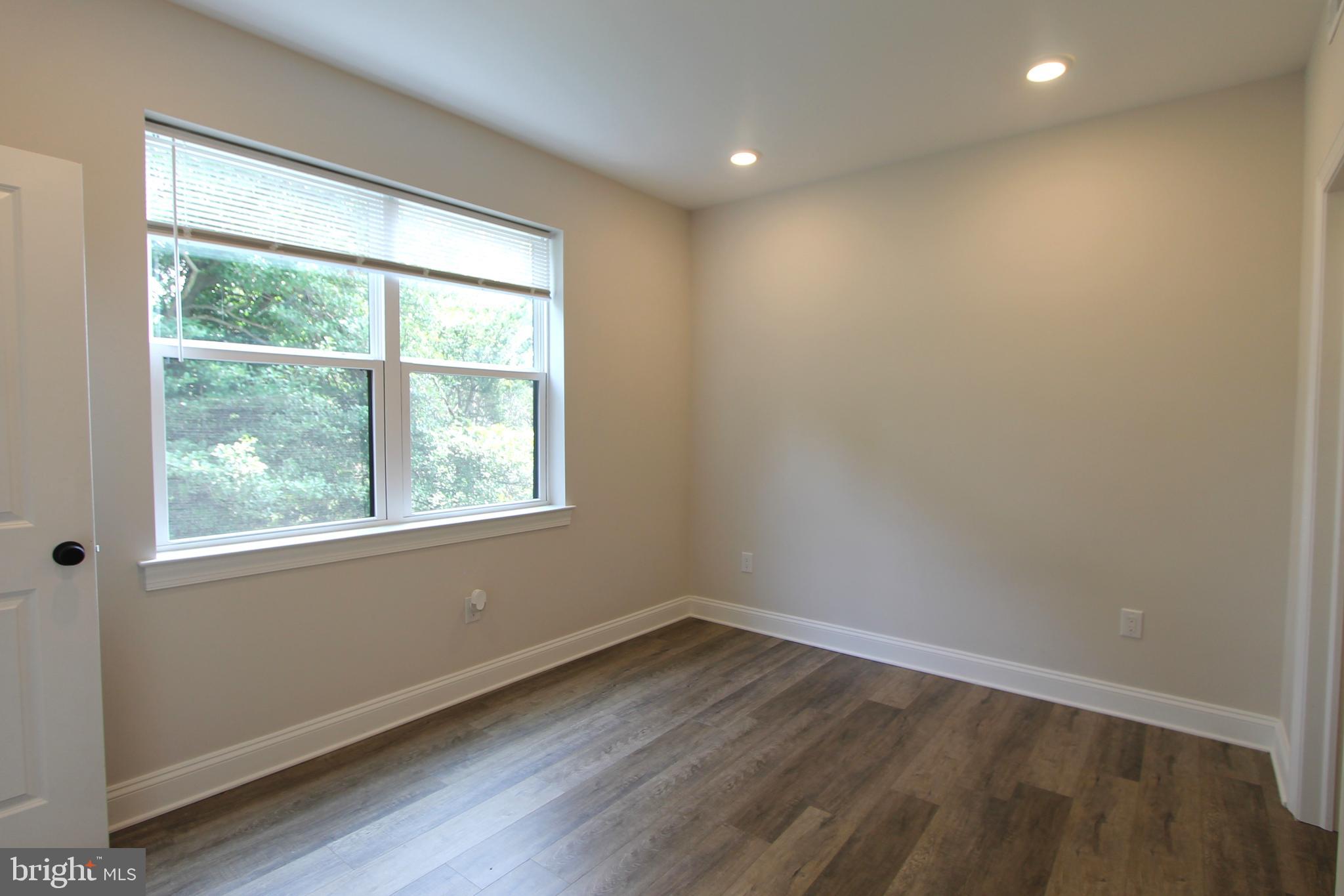 492 Roxborough Avenue, Unit 403 Philadelphia, PA 19128 - Photo 7 of 28 an empty room with wooden floor and windows