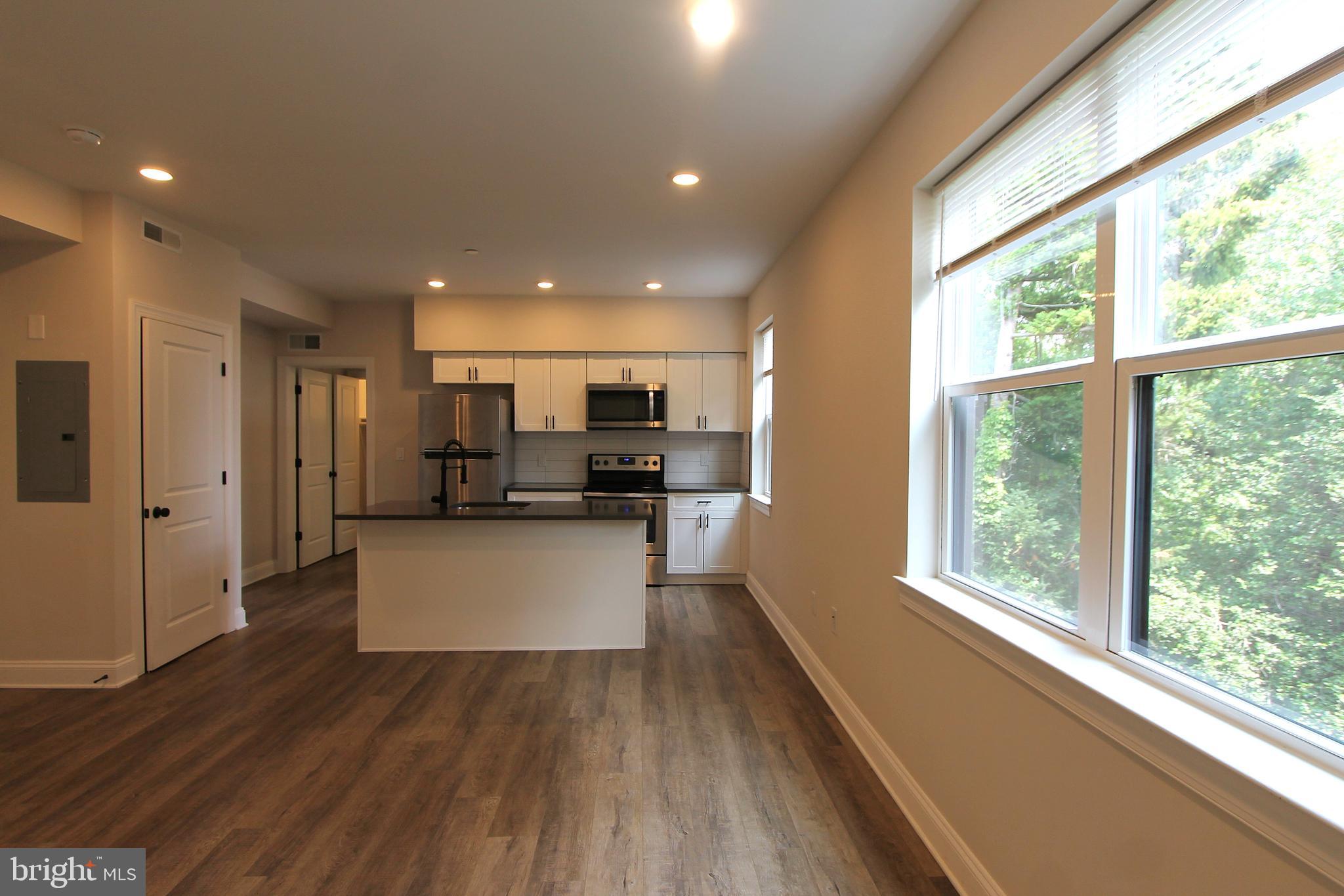 492 Roxborough Avenue, Unit 403 Philadelphia, PA 19128 - Photo 9 of 28 a kitchen with stainless steel appliances refrigerator and window