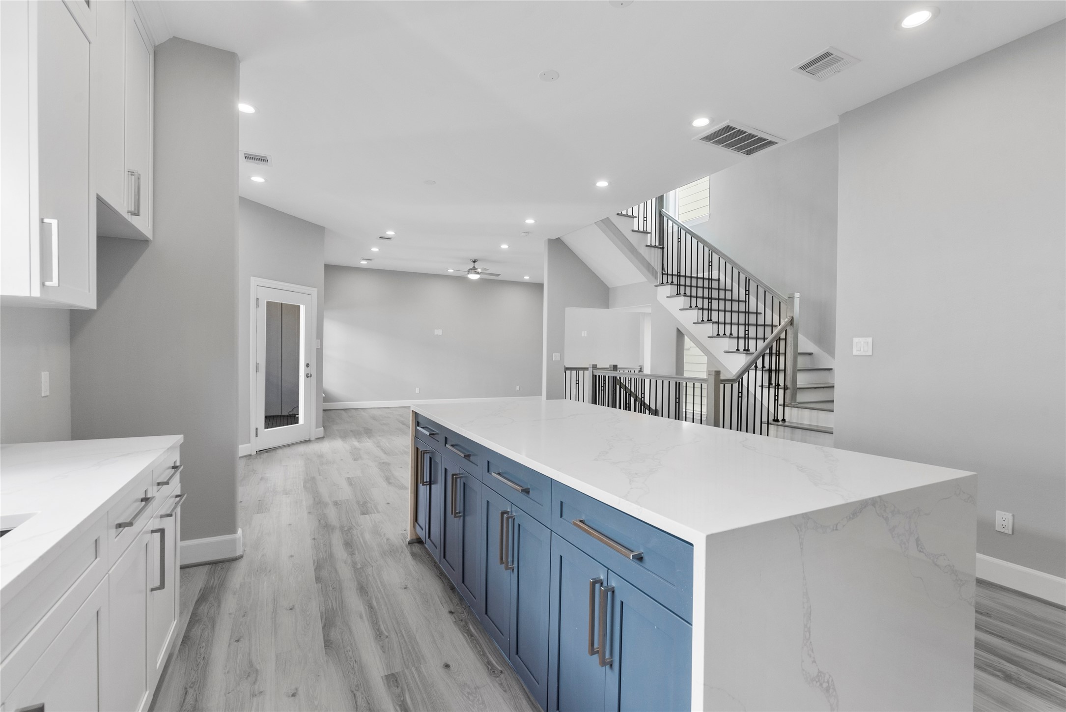 1122 West 16th Street, Unit B Houston, TX 77008 - Photo 16 of 31 a kitchen with a sink a wooden floor and white cabinets