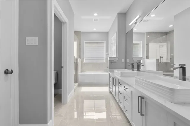 a spacious bathroom with a double vanity sink a mirror and a shower