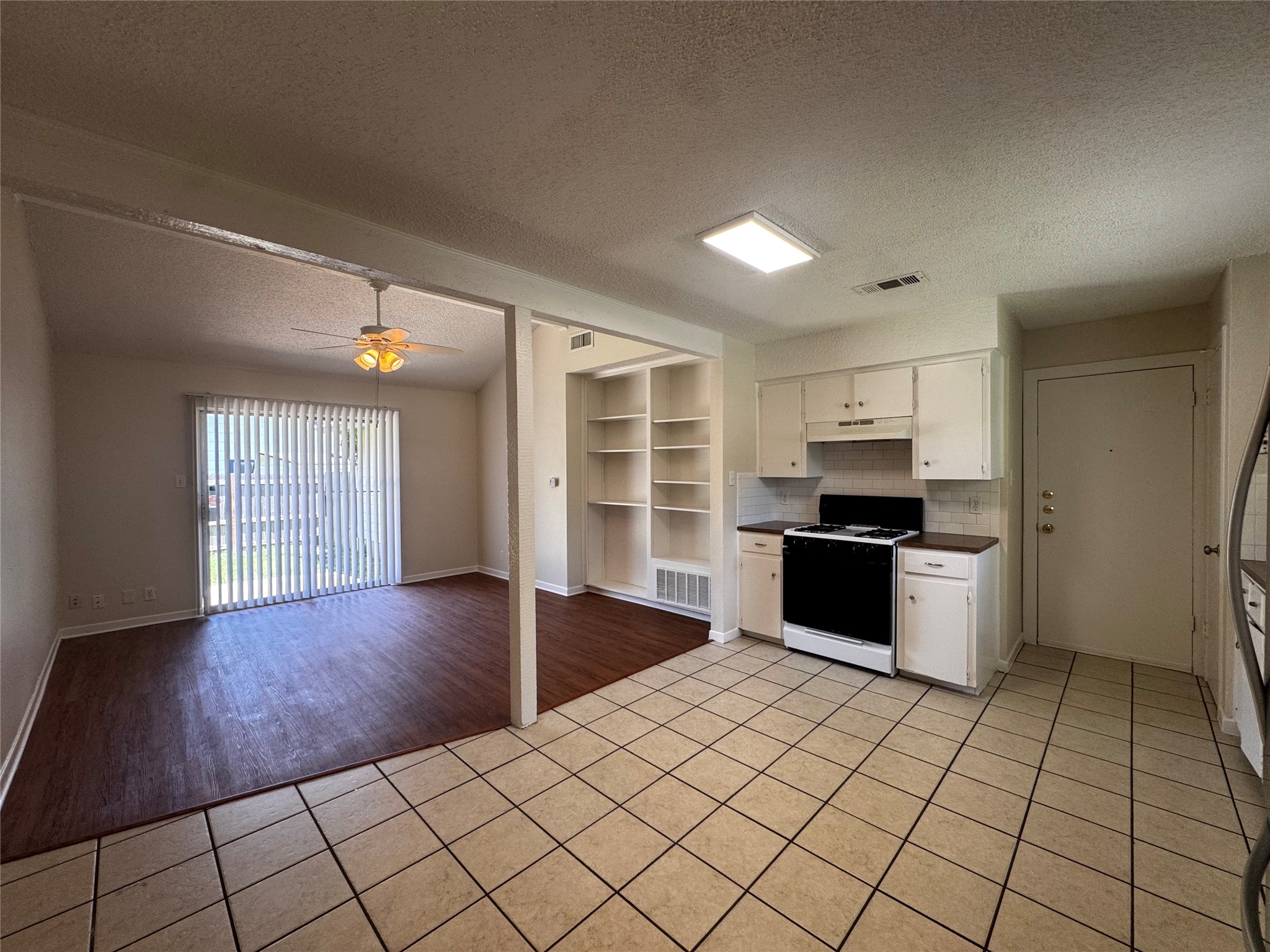 5916 A Cherry Loop Austin, TX 78745 - Photo 3 of 12 Functional kitchen with ample cabinet space opens to a spacious living area featuring wood flooring.