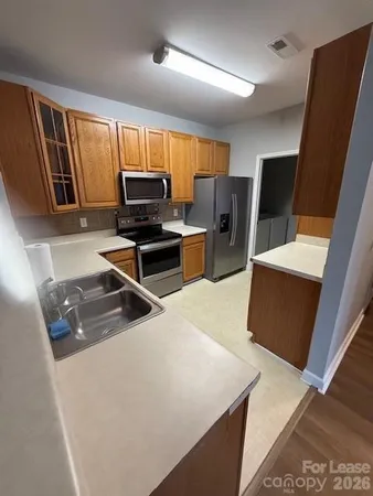 a living room with stainless steel appliances furniture and a large window