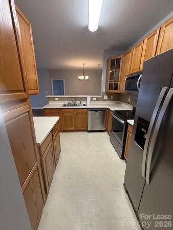 a kitchen with table chairs and wooden cabinets