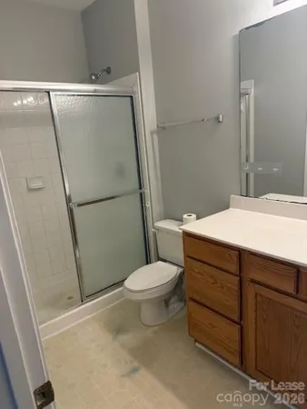 a bathroom with a sink a toilet a mirror and shower