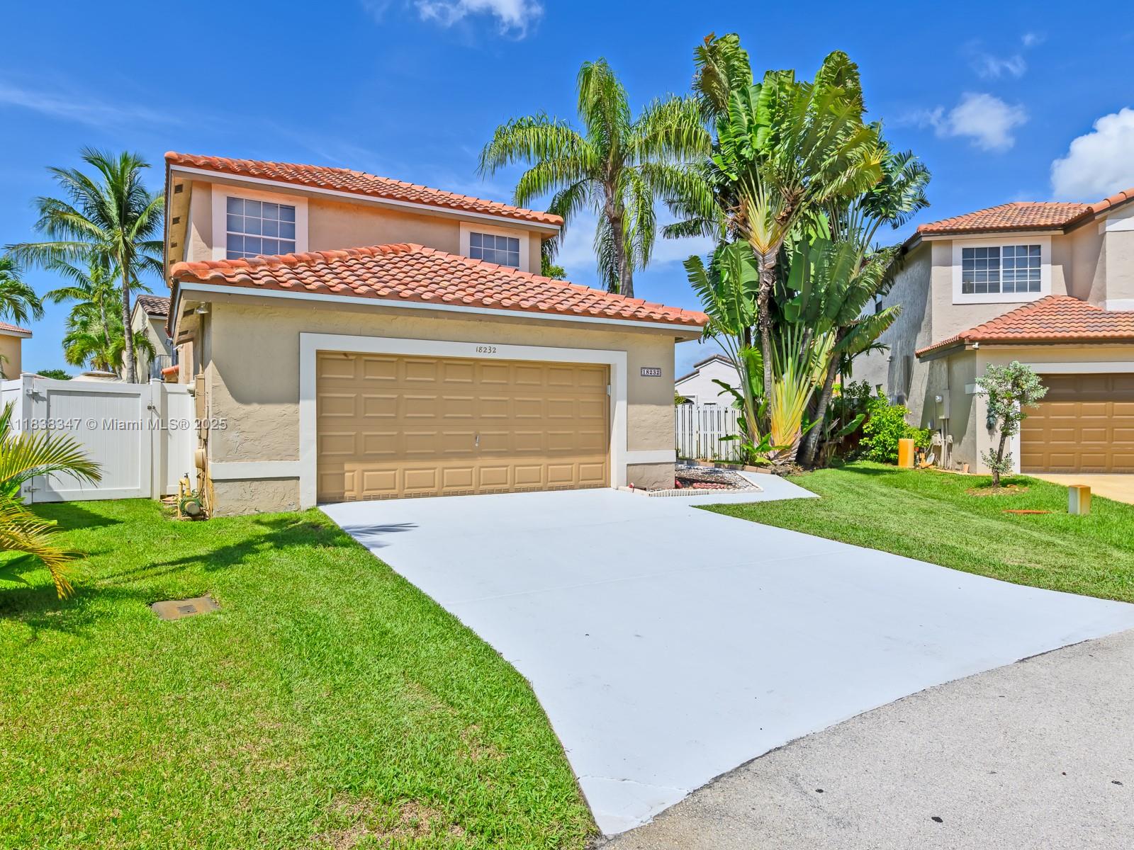 18232 Southwest 5th Street Pembroke Pines, FL 33029 - Photo 1 of 53 a front view of a house with a yard and garage