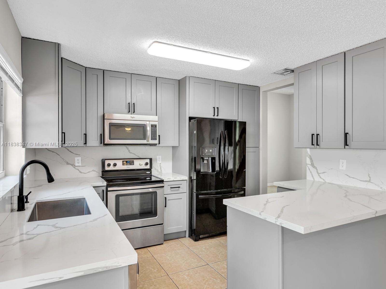 18232 Southwest 5th Street Pembroke Pines, FL 33029 - Photo 13 of 53 a kitchen with a sink a stove and refrigerator