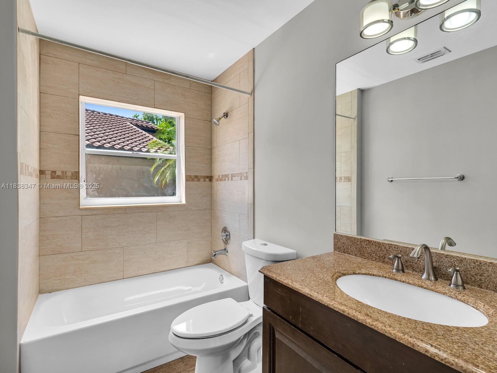 18232 Southwest 5th Street Pembroke Pines, FL 33029 - Photo 17 of 53 a bathroom with a granite countertop toilet a sink and a mirror