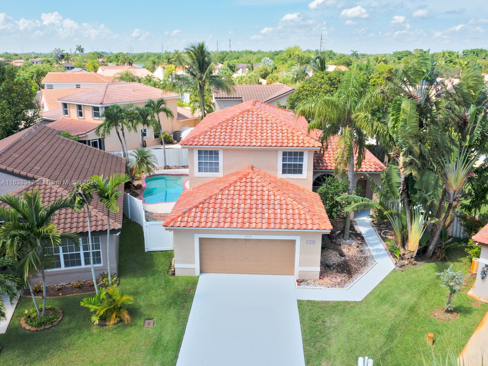 18232 Southwest 5th Street Pembroke Pines, FL 33029 - Photo 2 of 53 a front view of a house with a yard and outdoor seating
