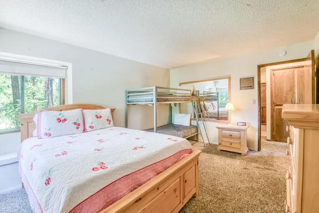 a bathroom with a granite countertop sink a toilet a mirror and shower