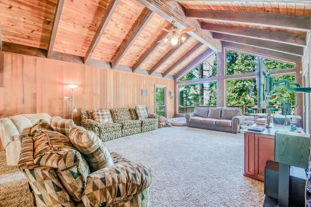 a view of roof deck with wooden floor and fence with a floor to ceiling window