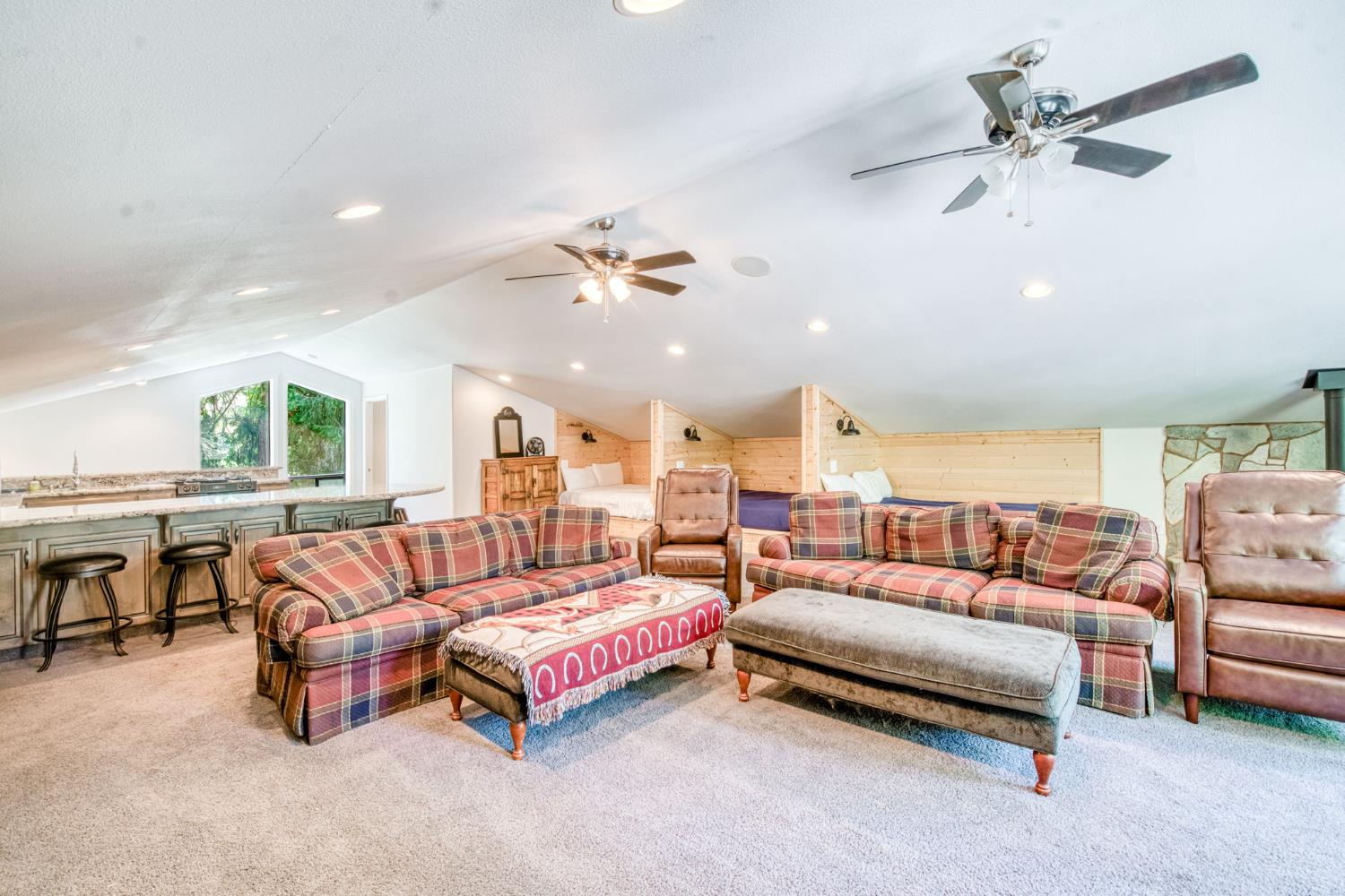 39145 Checkerbloom Lane Shaver Lake, CA 93664 - Photo 29 of 58 a spacious bedroom with a bed a couch and a chandelier fan