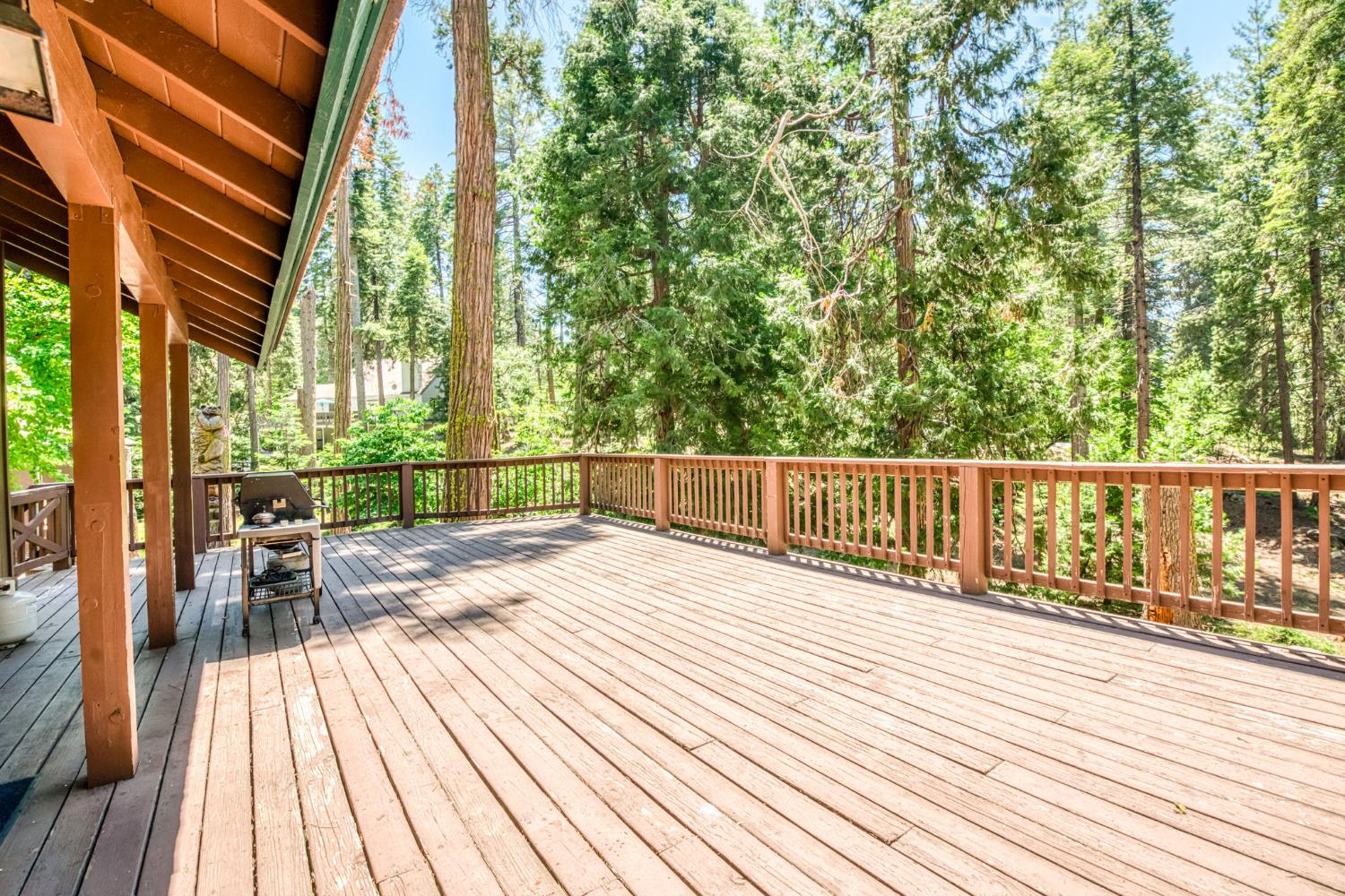 39145 Checkerbloom Lane Shaver Lake, CA 93664 - Photo 50 of 58 a view of a balcony with wooden floor next to a yard