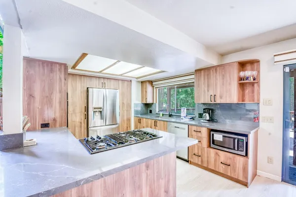 a kitchen with stainless steel appliances granite countertop a sink stove and refrigerator