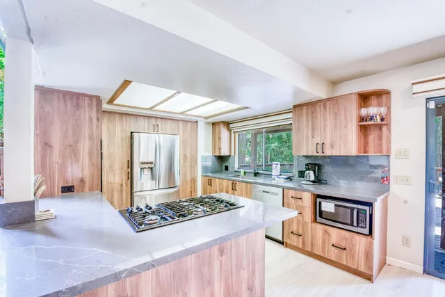 a kitchen with stainless steel appliances granite countertop a sink stove and refrigerator
