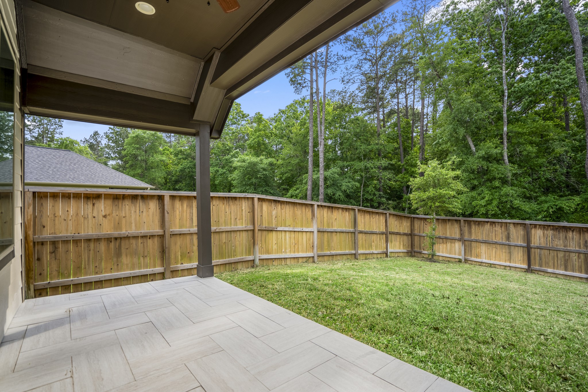 334 Topper Pines Drive Montgomery, TX 77316 - Photo 35 of 49 Stepping outside, the covered patio opens to a fenced backyard with the wooded greenbelt just beyond, giving you a shaded spot to sit back while still having open lawn space to enjoy.