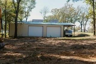a backyard of a house with large trees and outdoor seating