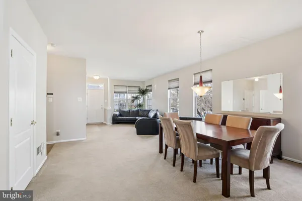 a kitchen with stainless steel appliances granite countertop a stove a sink a microwave a dining table and chairs