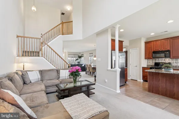 a kitchen with stainless steel appliances granite countertop a stove a sink a refrigerator a dining table and chairs