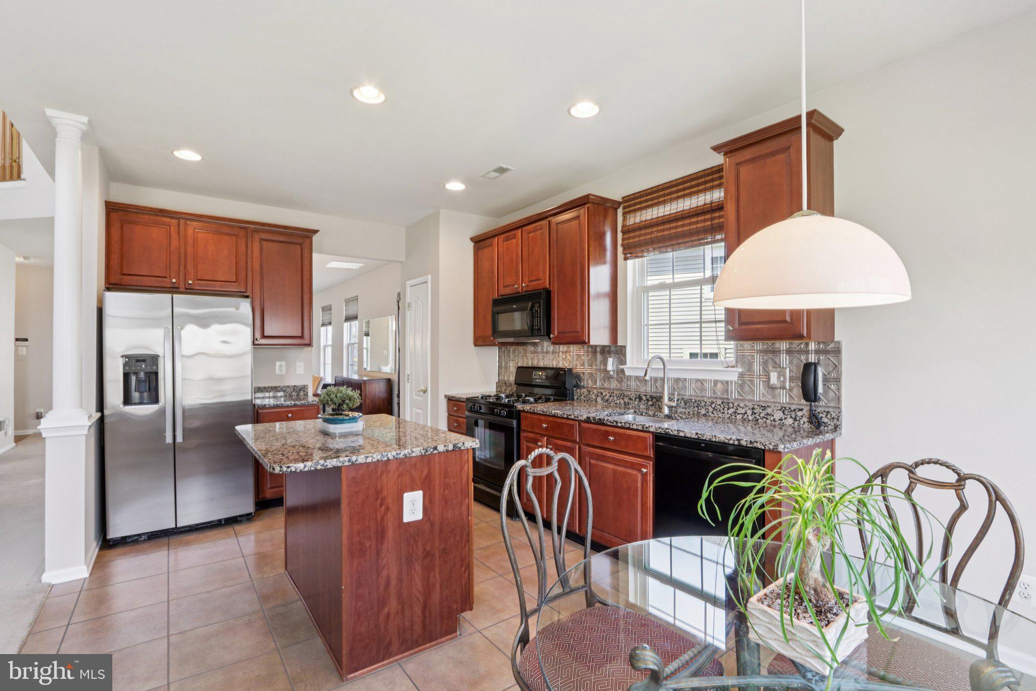 24 Compass Circle Mount Laurel, NJ 08054 - Photo 21 of 61 a kitchen with stainless steel appliances granite countertop a stove a sink a refrigerator a dining table and chairs