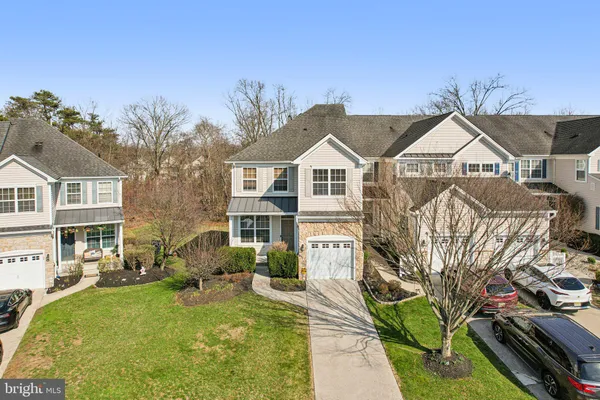a view of a big yard in front of a brick house with large windows