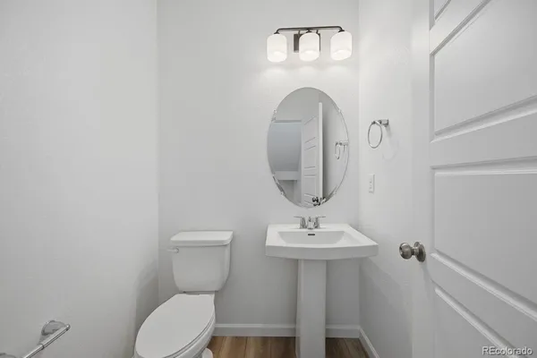 a bathroom with a toilet a sink and mirror