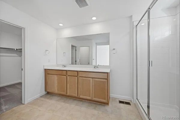 a spacious bathroom with a mirror a sink and a shower
