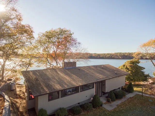 an aerial view of a house with a yard lake and mountain view in back
