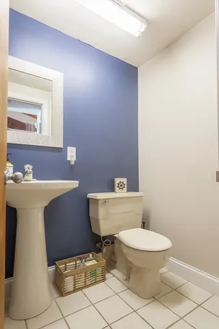 a bathroom with a toilet a sink and mirror