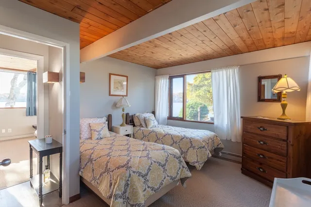 a bedroom with two beds and painting on the wall