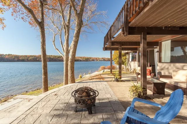 a view of a patio with lawn chairs wooden floor and floor to ceiling window