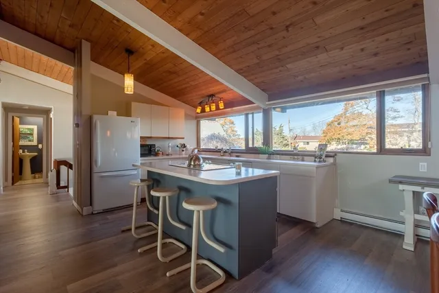 a kitchen with wooden floor and white appliances