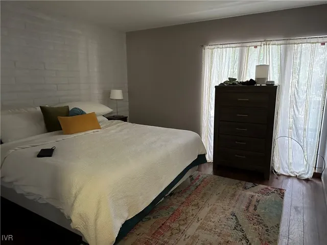 a bedroom with a bed and two windows