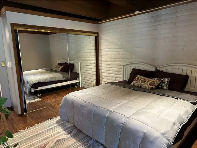 a bedroom with two bed and a mirror