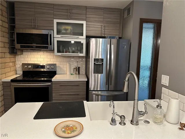 a kitchen with a sink and stainless steel appliances