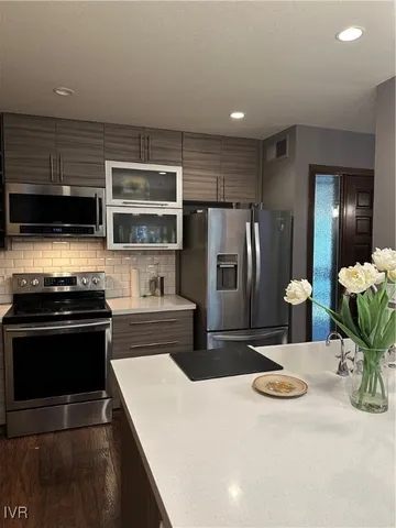 a kitchen with stainless steel appliances a stove a refrigerator and a stove