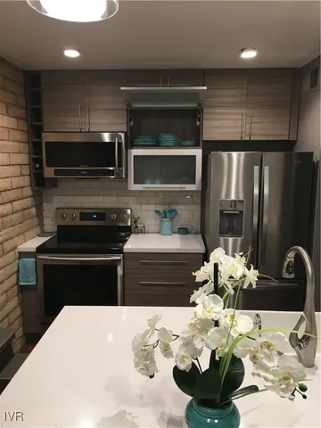 a kitchen with stainless steel appliances kitchen island granite countertop a refrigerator and a stove top oven