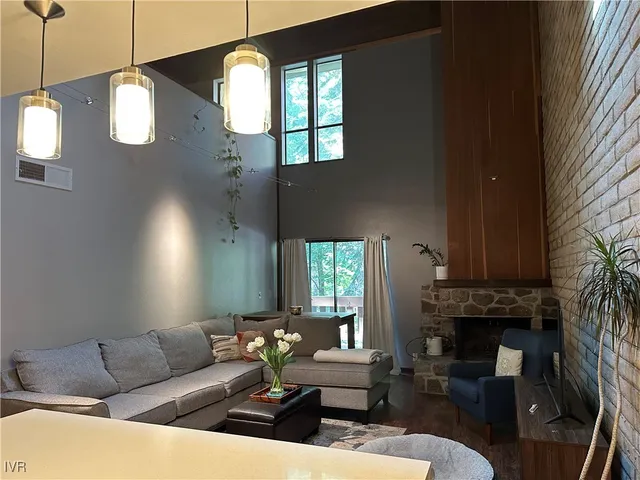 a living room with furniture a fireplace and a large window