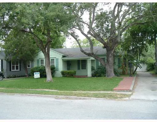 a view of a tree in front of a brick house