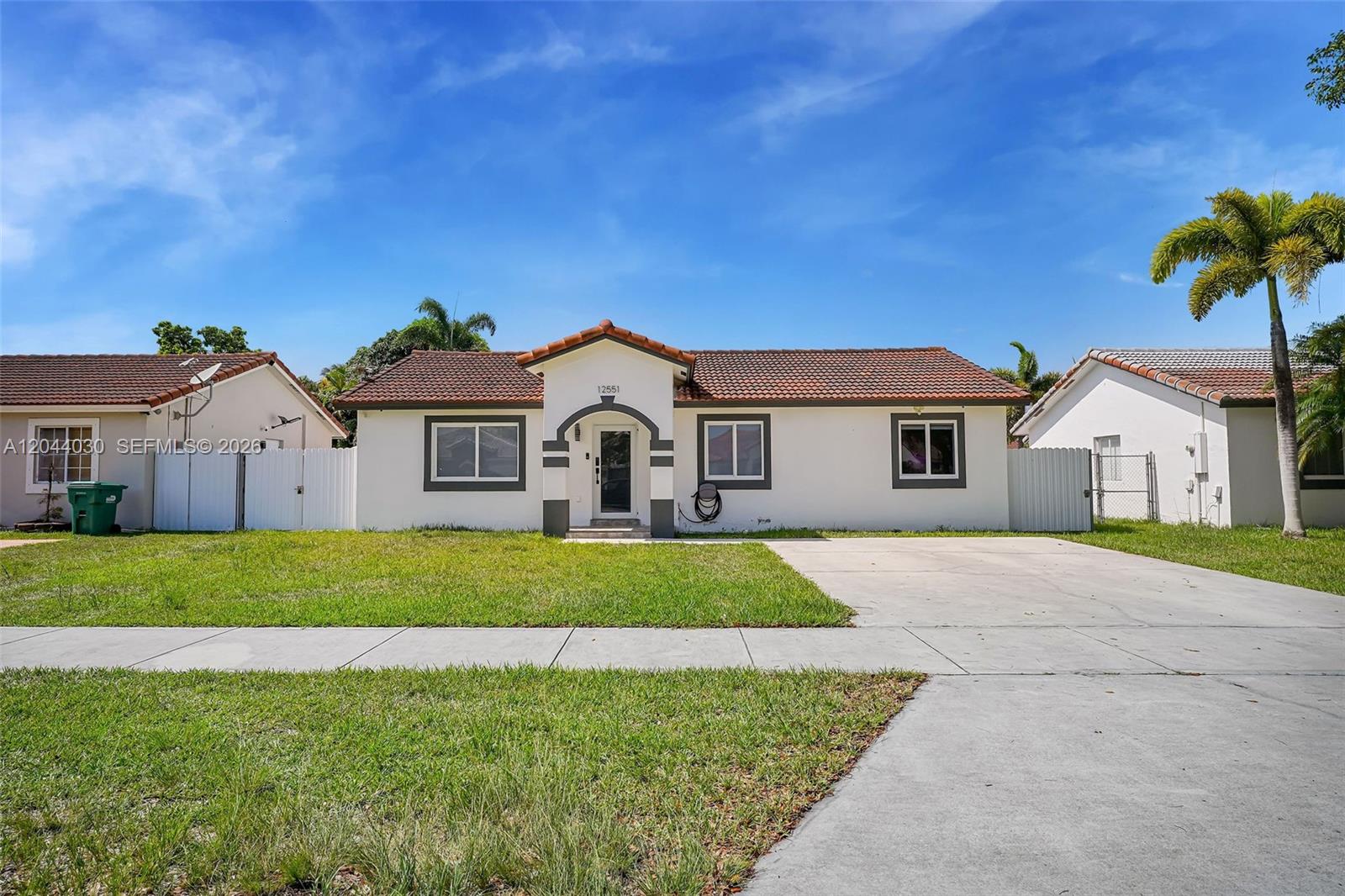 12551 Southwest 223rd Street Miami, FL 33170 - Photo 1 of 35 a front view of a house with a yard and garage