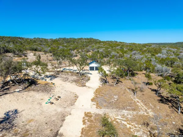 an aerial view of residential houses with outdoor space and trees