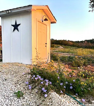 a view of backyard with potted plants and wooden fence