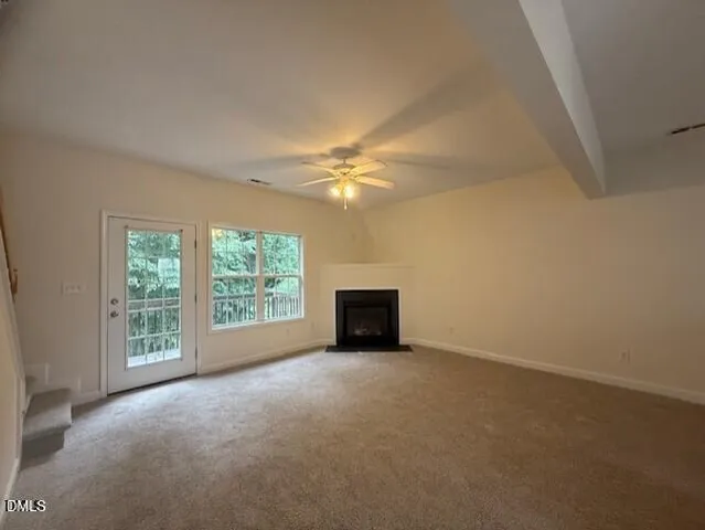an empty room with windows and ceiling fan