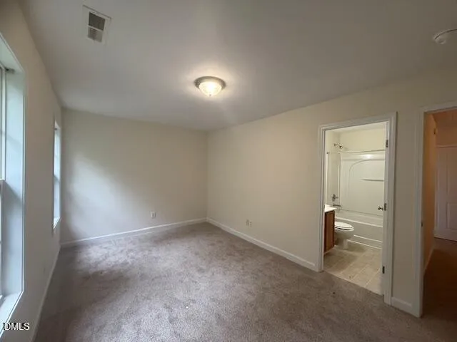 en empty room with windows and chandelier fan