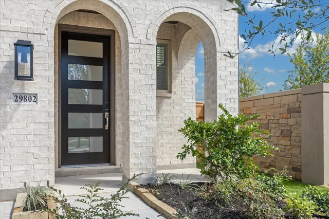 a front view of a house with a glass windows and potted plants