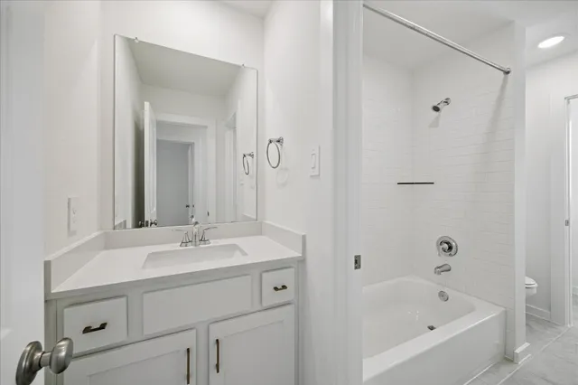 a bathroom with a bathtub shower sink and mirror