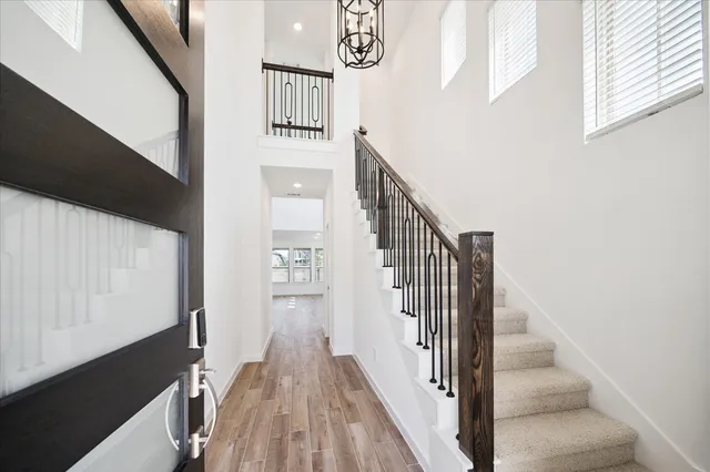 a view of staircase with lots of frames on wall and a window