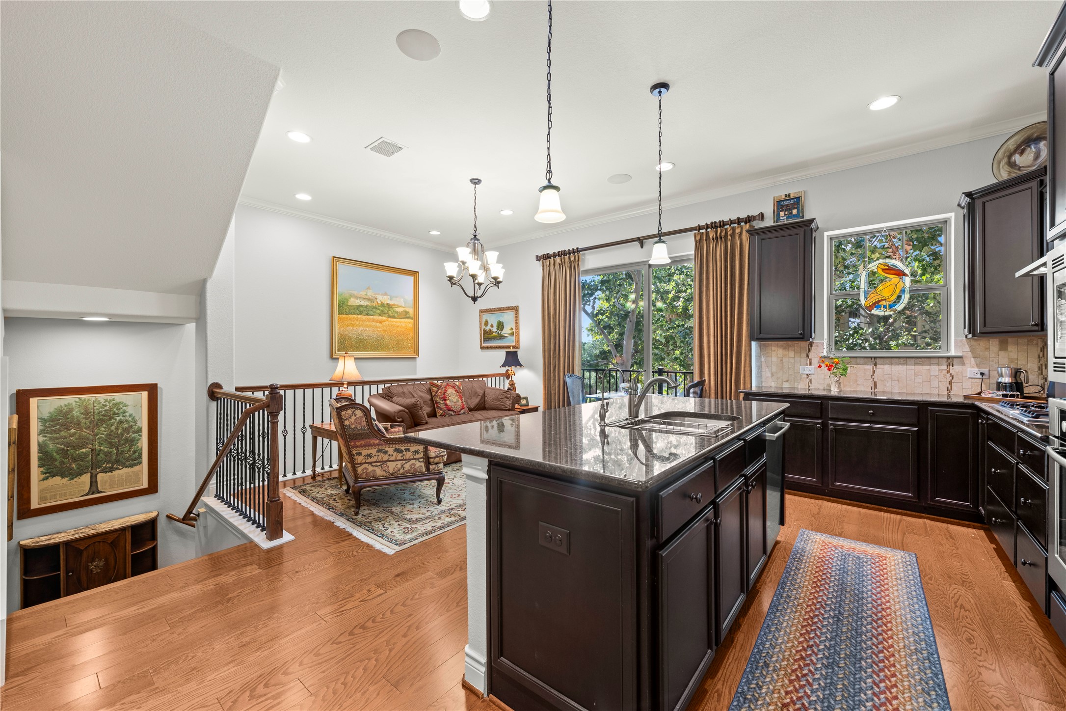 204 Adams Street Georgetown, TX 78628 - Photo 5 of 33 A well-appointed kitchen with a cozy living room, all illuminated by recessed lighting.